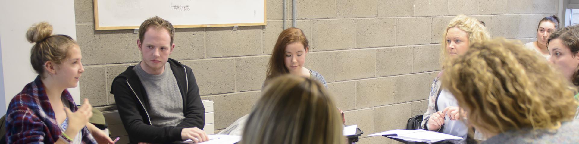 Students sitting in a circle doing group work and discussion